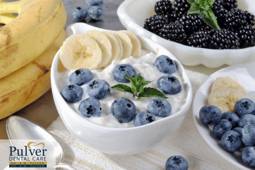 Healthy bowl of yogurt topped with berries and banana slices for post-oral surgery recovery