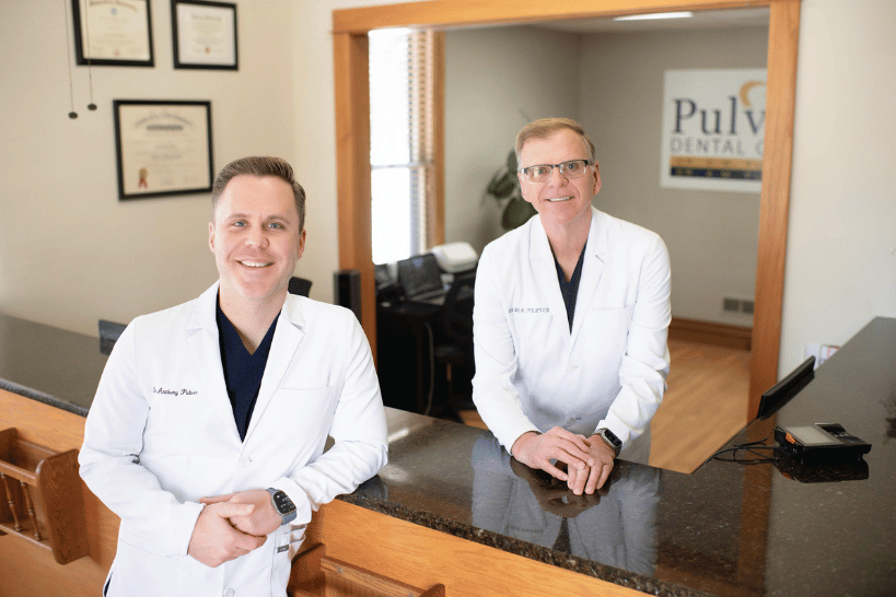 Dr. Anthony Pulver and Dr. Don Pulver smiling together at clinic reception area