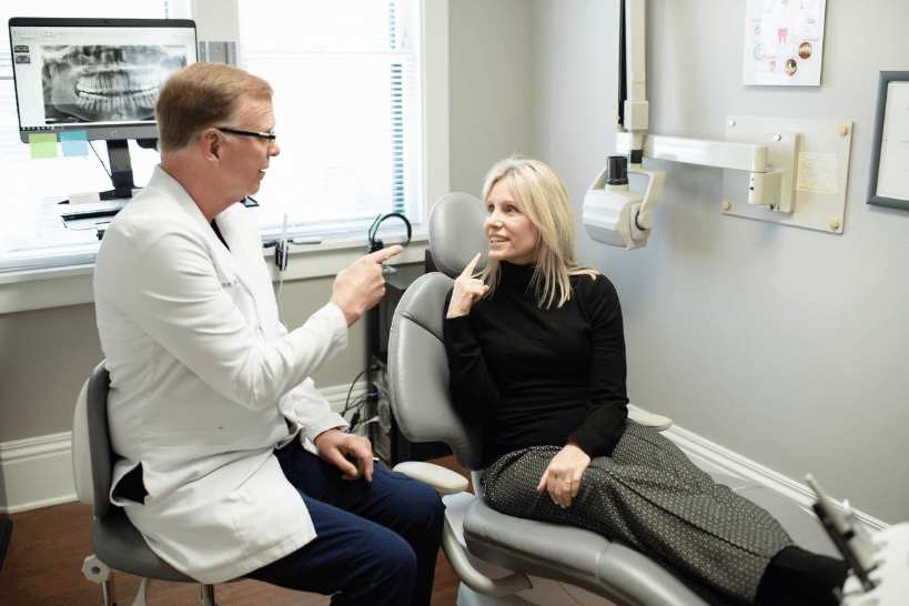 Dr. Don Pulver discussing recovery meal plan with patient in dental chair